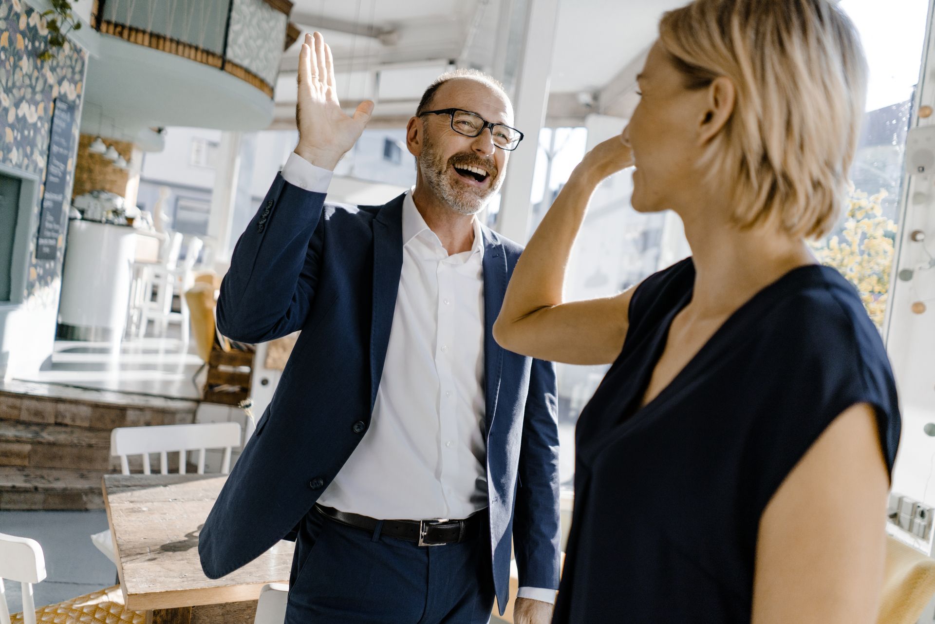 A man and a woman stand in a room and smile, symbolizing teamwork and partnership in the field of information security.