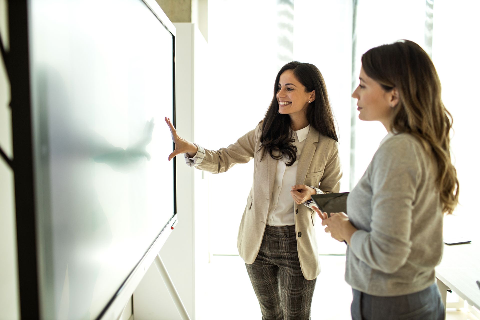 A woman points to a blackboard and discusses information security management.