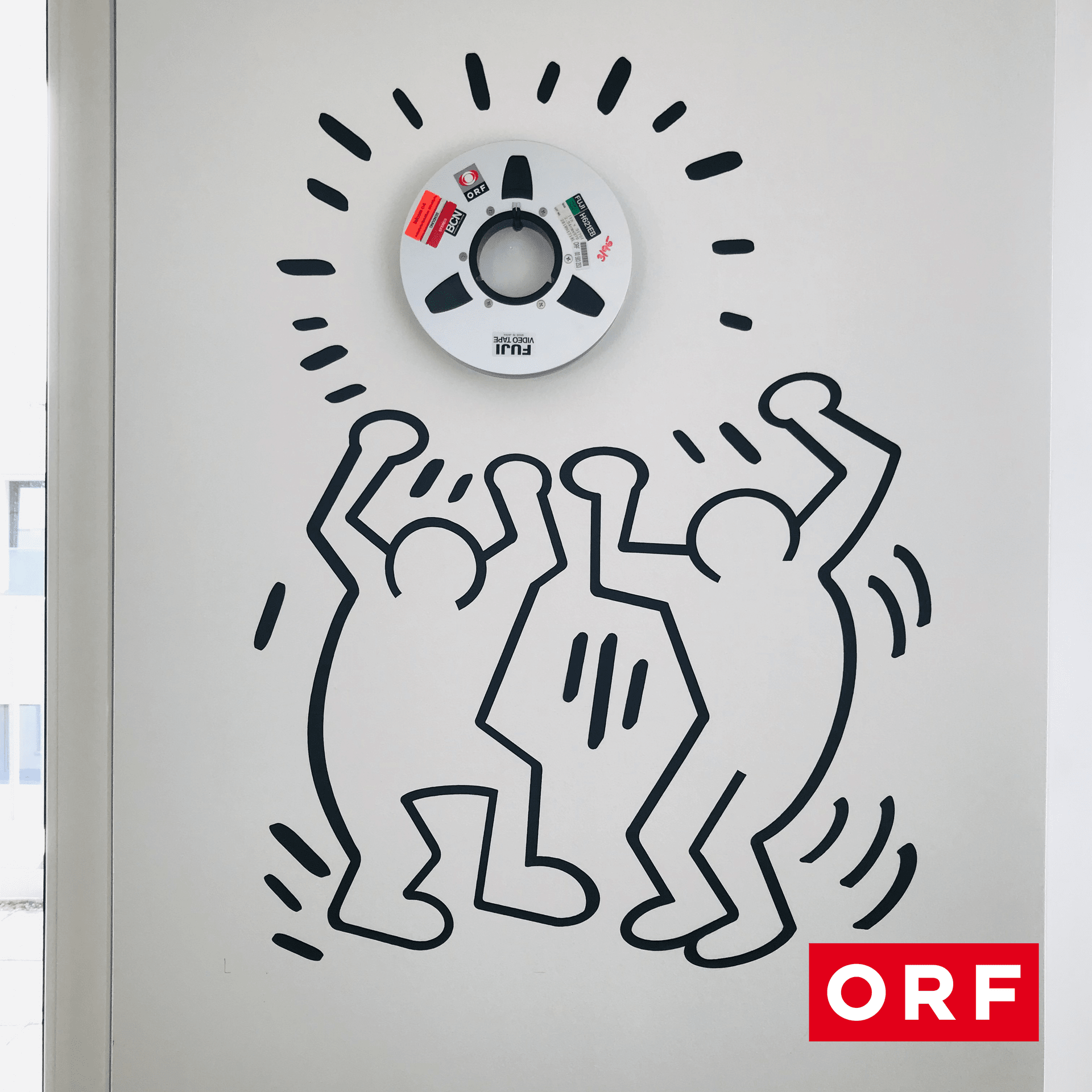 CD a kresba tančících lidí na stěně na CANCOM smART Walk.