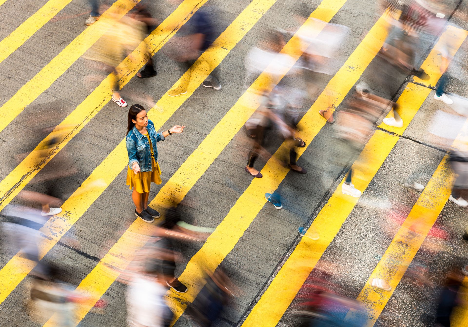 Woman stands on a crosswalk, symbolizing the seamless customer interactions in CANCOM Austria's Customer Experience Management.