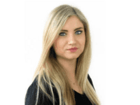 Frau mit blonden, langen Haaren lächelt in die Kamera.