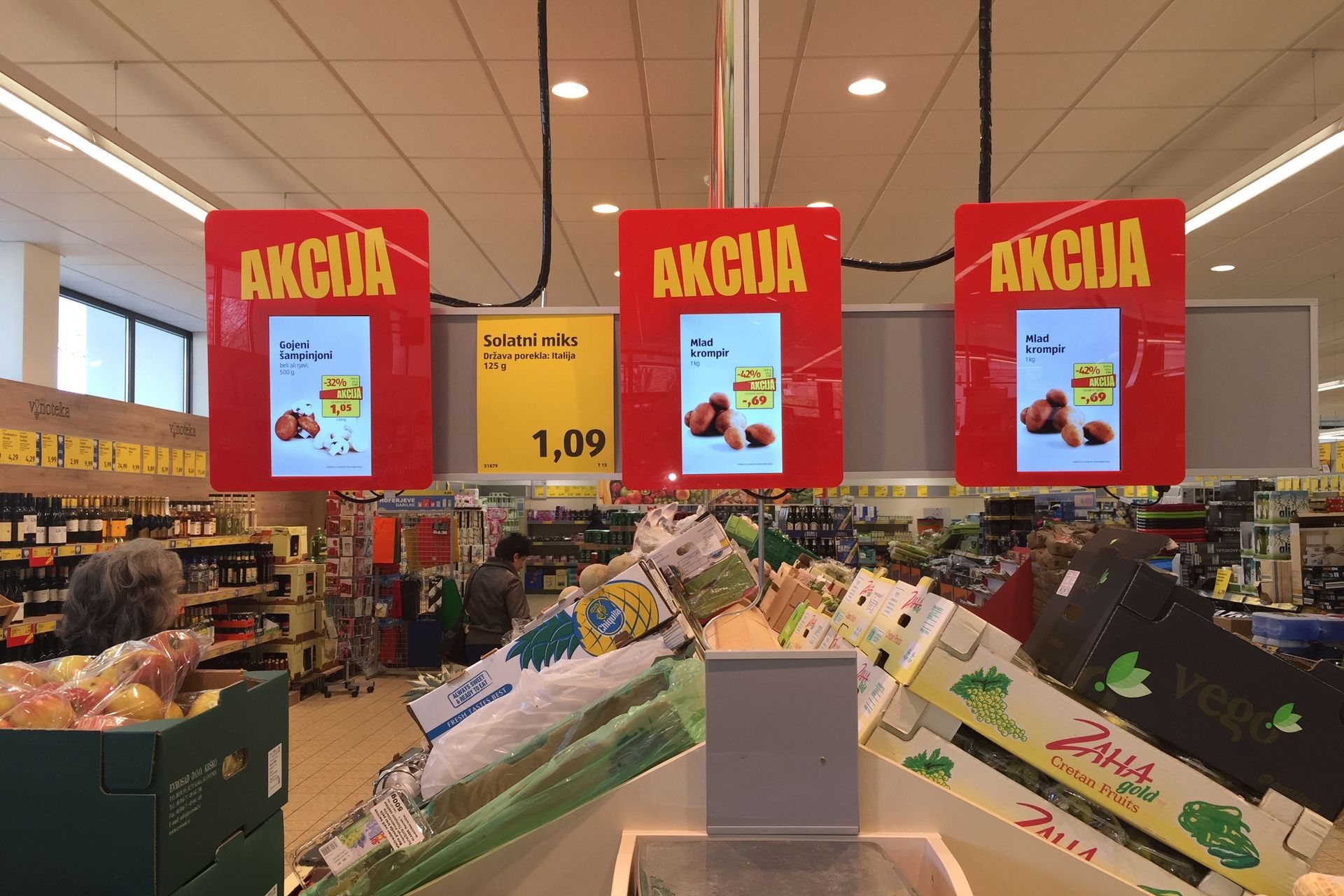 Einzelhandelsgeschäft mit digitalen Preisschildern und Werbetafeln, die auf CANCOM Digital Signage Lösungen hinweisen.
