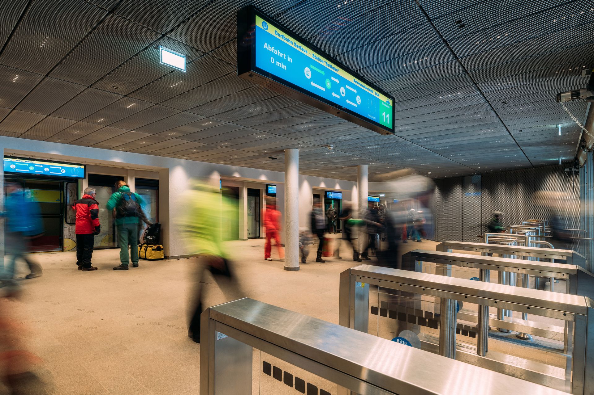 Gruppe von Personen in einem Flughafen, umgeben von Digital Signage Displays von CANCOM.